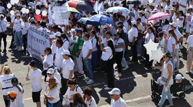 Multitud vestida de blanco marcha por la paz en Culiacán con sombrillas y pancartas